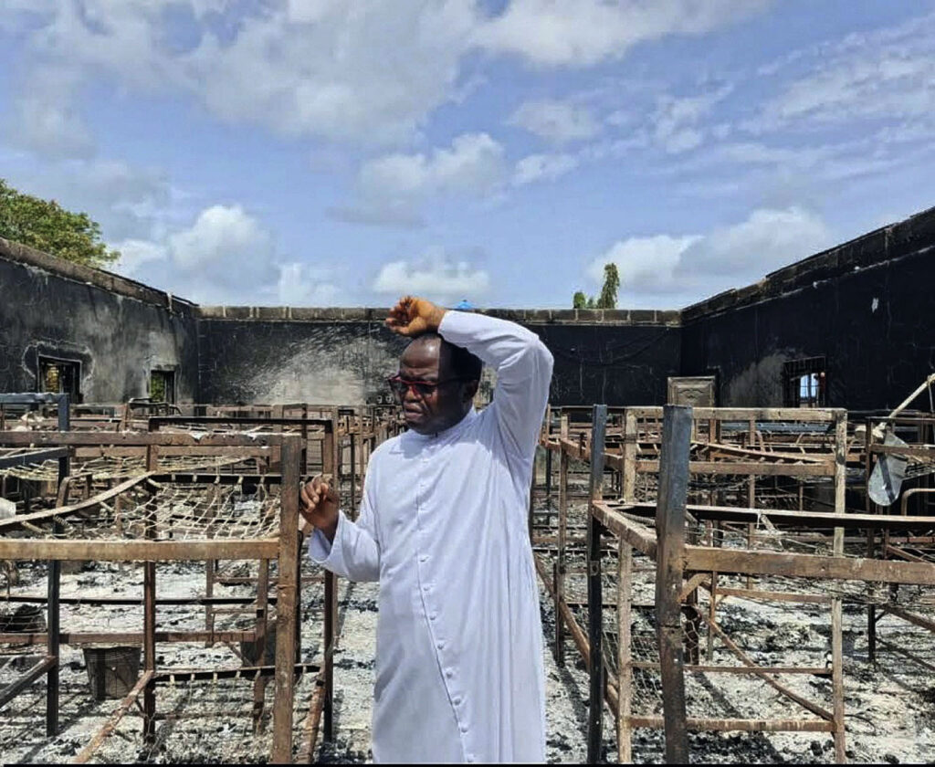 Father Isaac Shalegh in the premises of the burnt building.