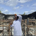 Father Isaac Shalegh in the premises of the burnt building.