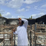 Father Isaac Shalegh in the premises of the burnt building.