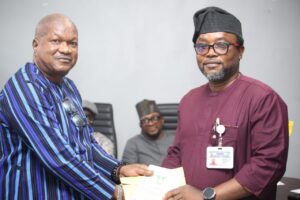 Outgoing Chairman Comrade Wole Dada (left) handing over to Comrade Ekip Ekip Eso