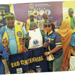 One of the beneficiaries of the food packs flanked by Lions Club members