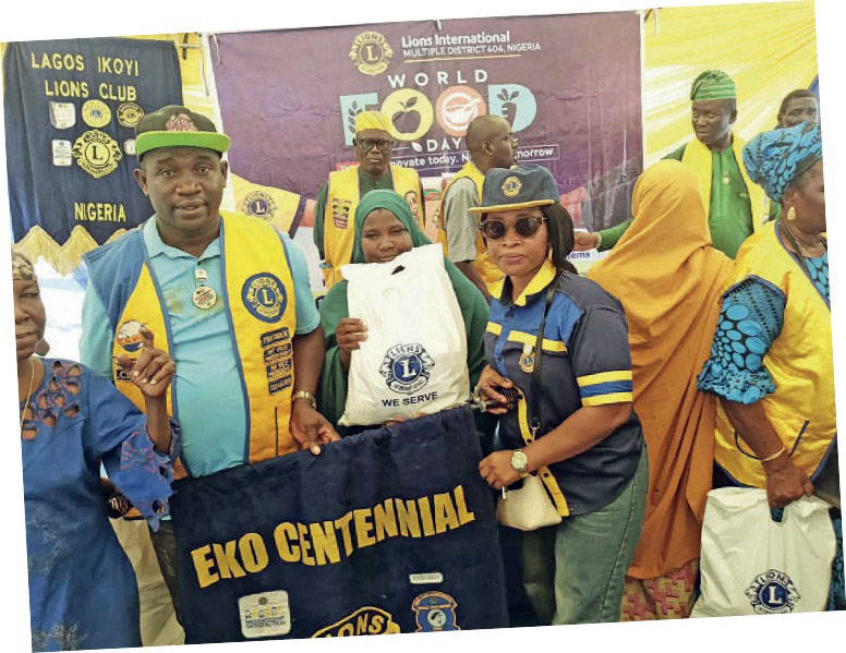 One of the beneficiaries of the food packs flanked by Lions Club members