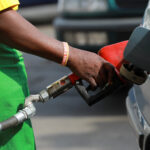 A gas station attendant pumps fuel into a customer’s car at the NNPC Mega petrol station in Abuja