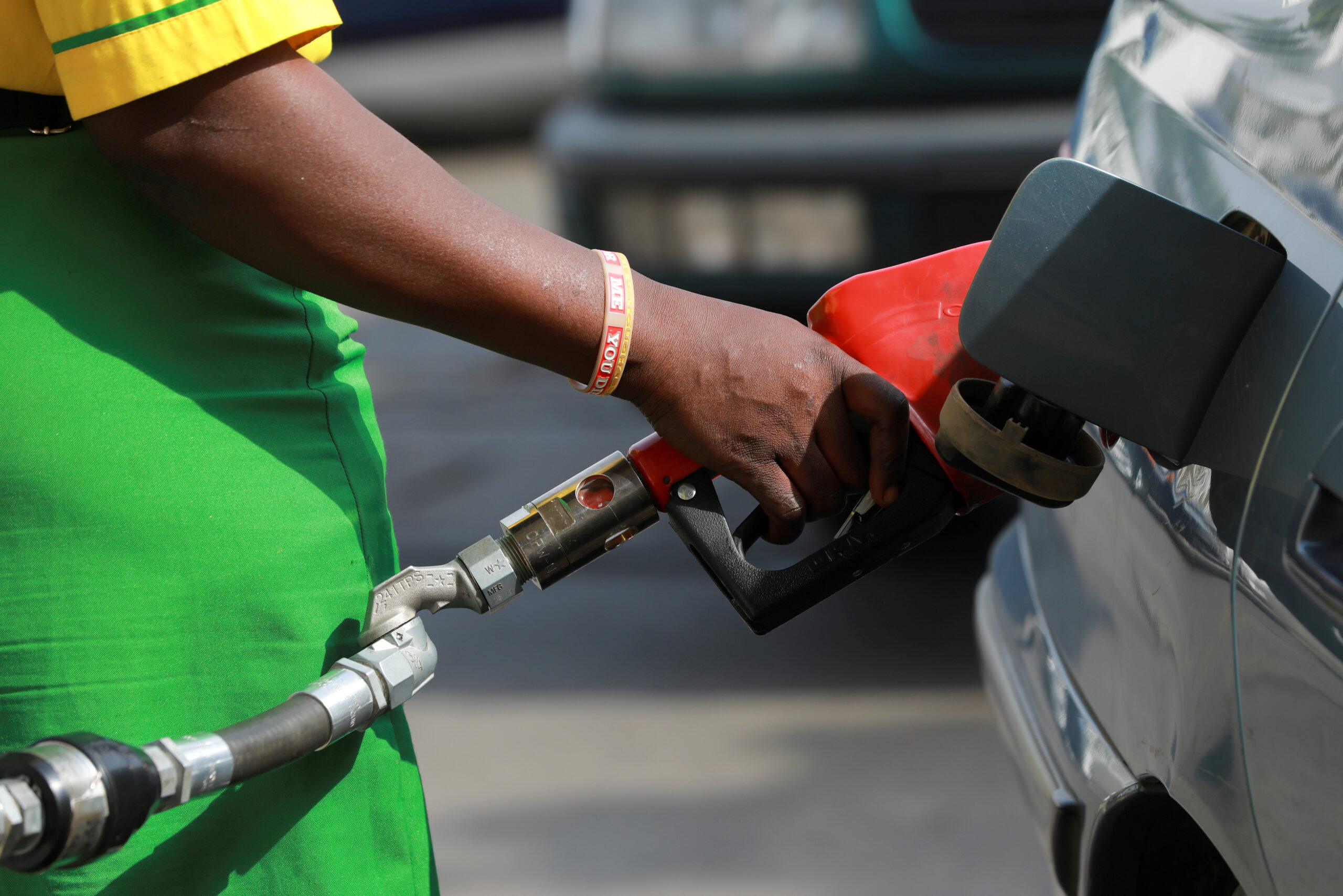 A gas station attendant pumps fuel into a customer’s car at the NNPC Mega petrol station in Abuja